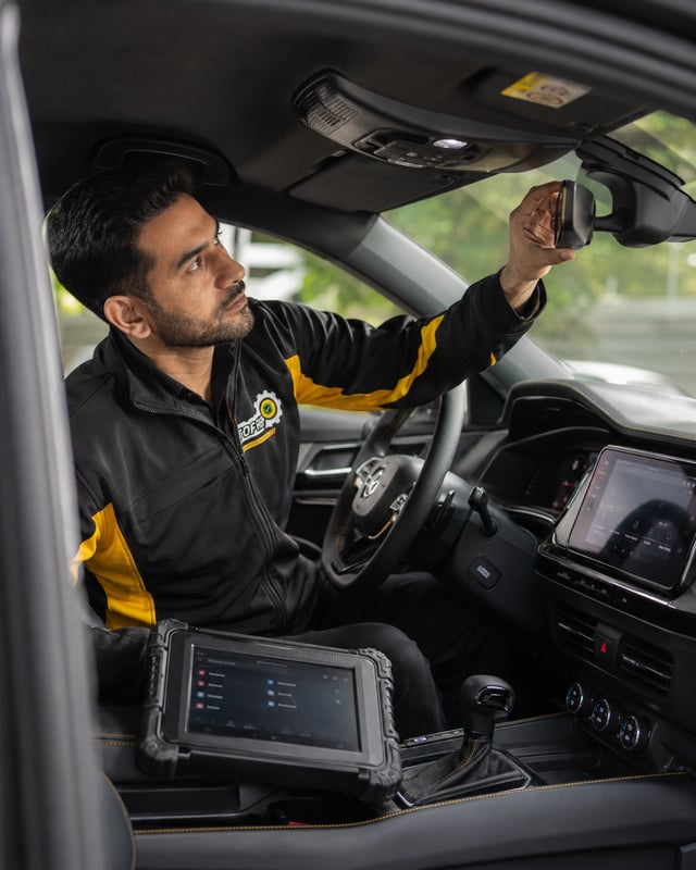 AutoFay inspector checking ADAS camera mirror and safety sensors inside a vehicle in UAE