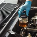 Inspector unscrewing brake fluid reservoir cap, clear fluid at MAX line visible through transparent tank, gloved hand steady, bright engine bay daylight