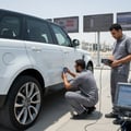 Wide shot of complete inspection setup, car with all doors and hood open, diagnostic tools on table nearby, paint gauge and OBD scanner visible, bright outdoor Dubai parking