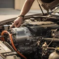 Inspector standing over open hybrid engine bay, pointing at electric motor beside petrol engine, dual system visible, bright outdoor Dubai sun