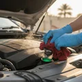 Inspector carefully twisting radiator cap with rag, pressure releasing with slight hiss, coolant level visible inside neck, hood open in Dubai outdoor sun