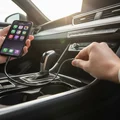 Close-up of inspector plugging USB cable into center console port, phone connected showing CarPlay on screen, bright interior from open sunroof